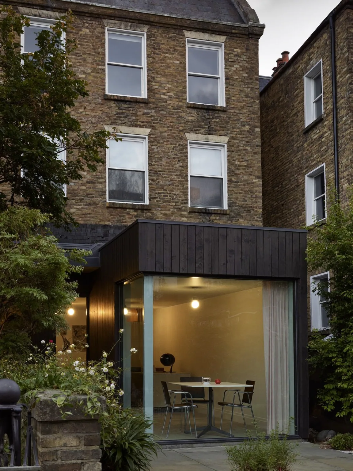 Timber-clad rear extension with a glazed corner window, viewed from the garden