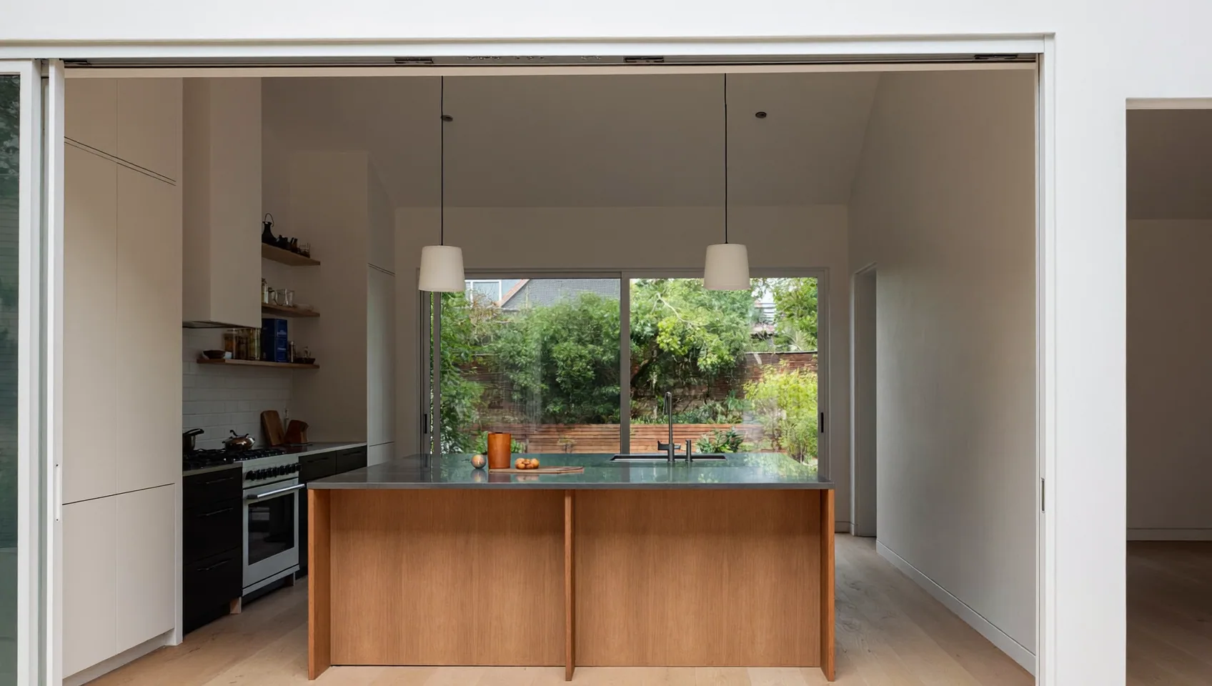 Kitchen extension with an oak island, pendant lights and a large window onto the garden