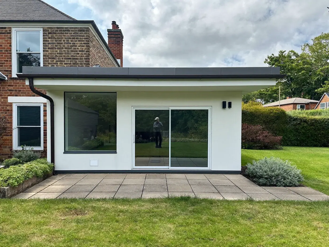 Brent: single-storey brick rear extension with dark sliding doors onto a lawn