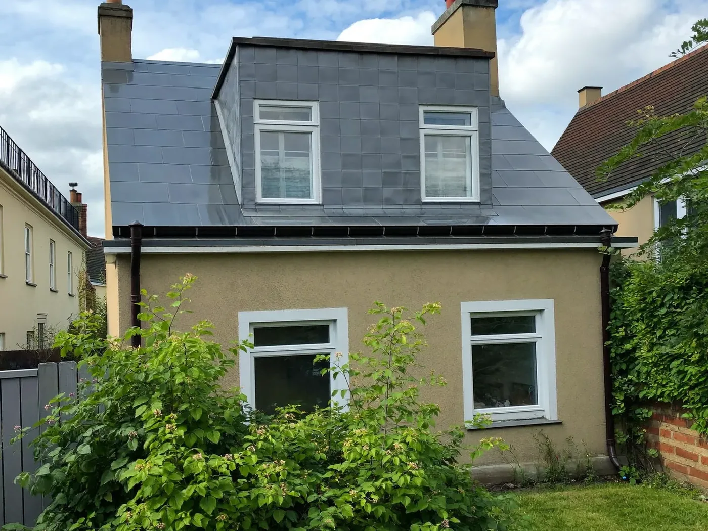 Brent: grey-clad box dormer loft conversion on the rear roof of a house with white windows