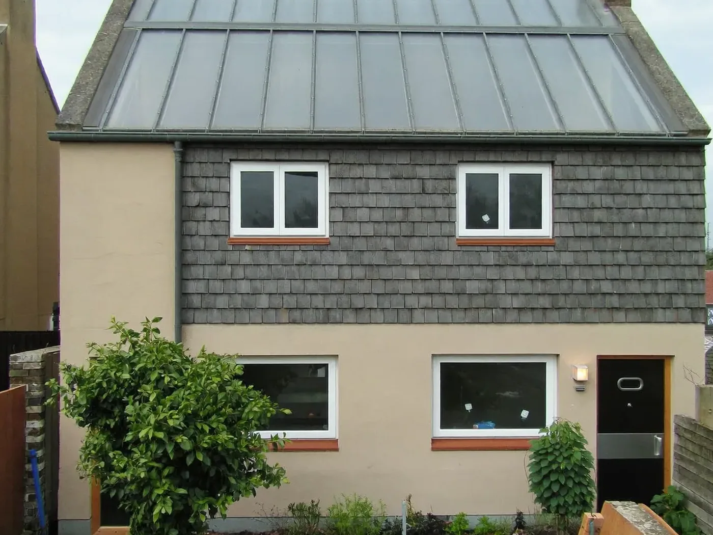 Bushey: grey-clad box dormer loft conversion on the rear roof of a house with white windows