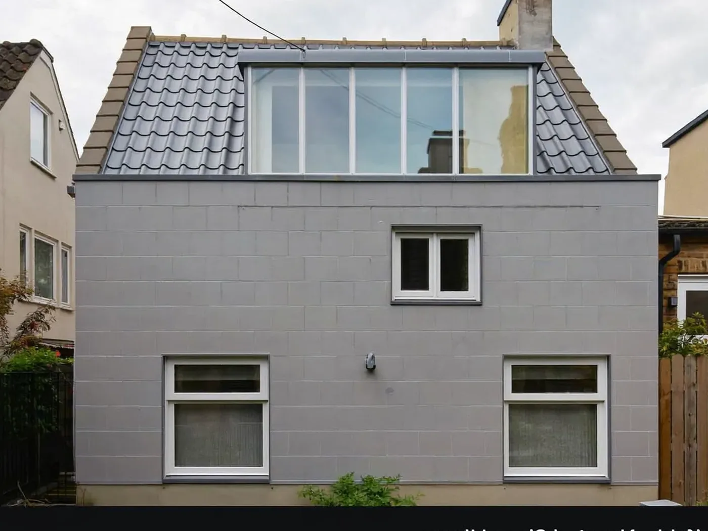 Croydon: grey-clad box dormer loft conversion on the rear roof of a house with white windows