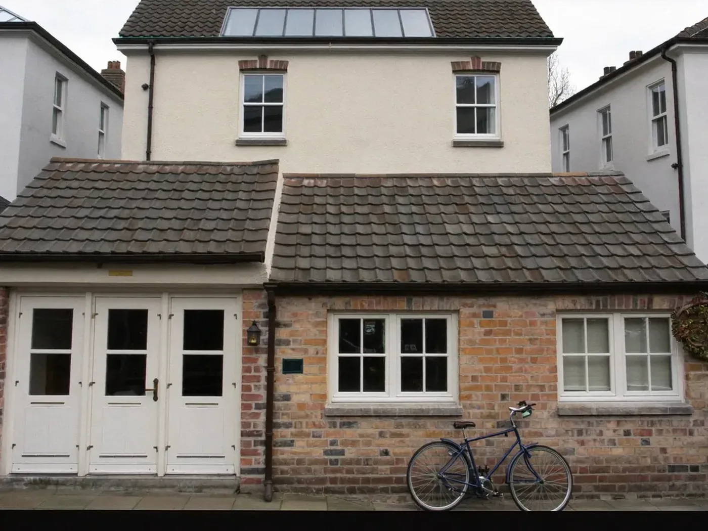 Ealing: brick side-return extension at the back of a terraced house with white French doors
