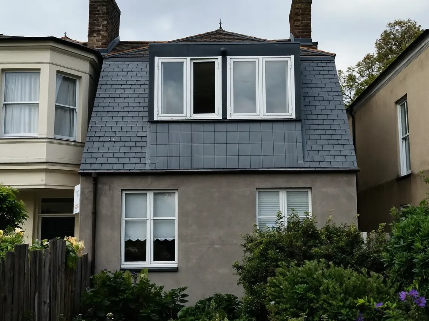 Epsom: grey-clad box dormer loft conversion on the rear roof of a house with white windows