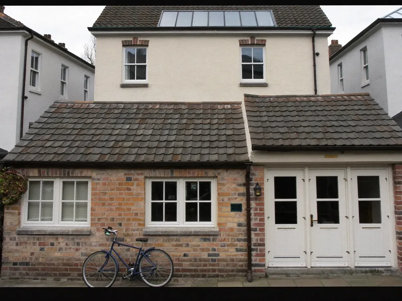 Lewisham: brick side-return extension at the back of a terraced house with white French doors
