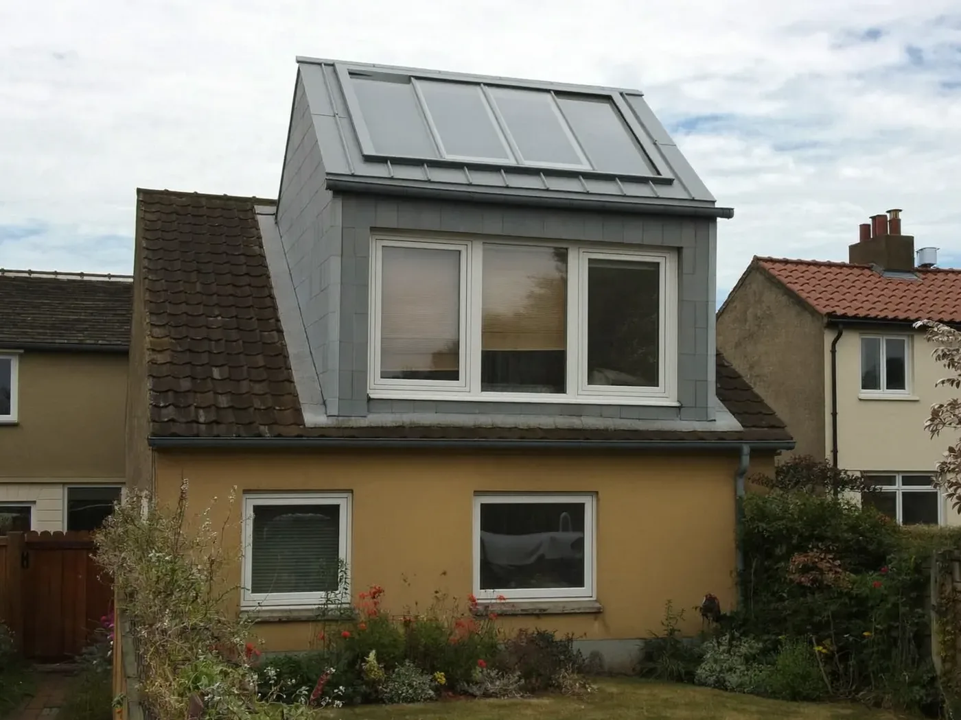 Merton: grey-clad box dormer loft conversion on the rear roof of a house with white windows