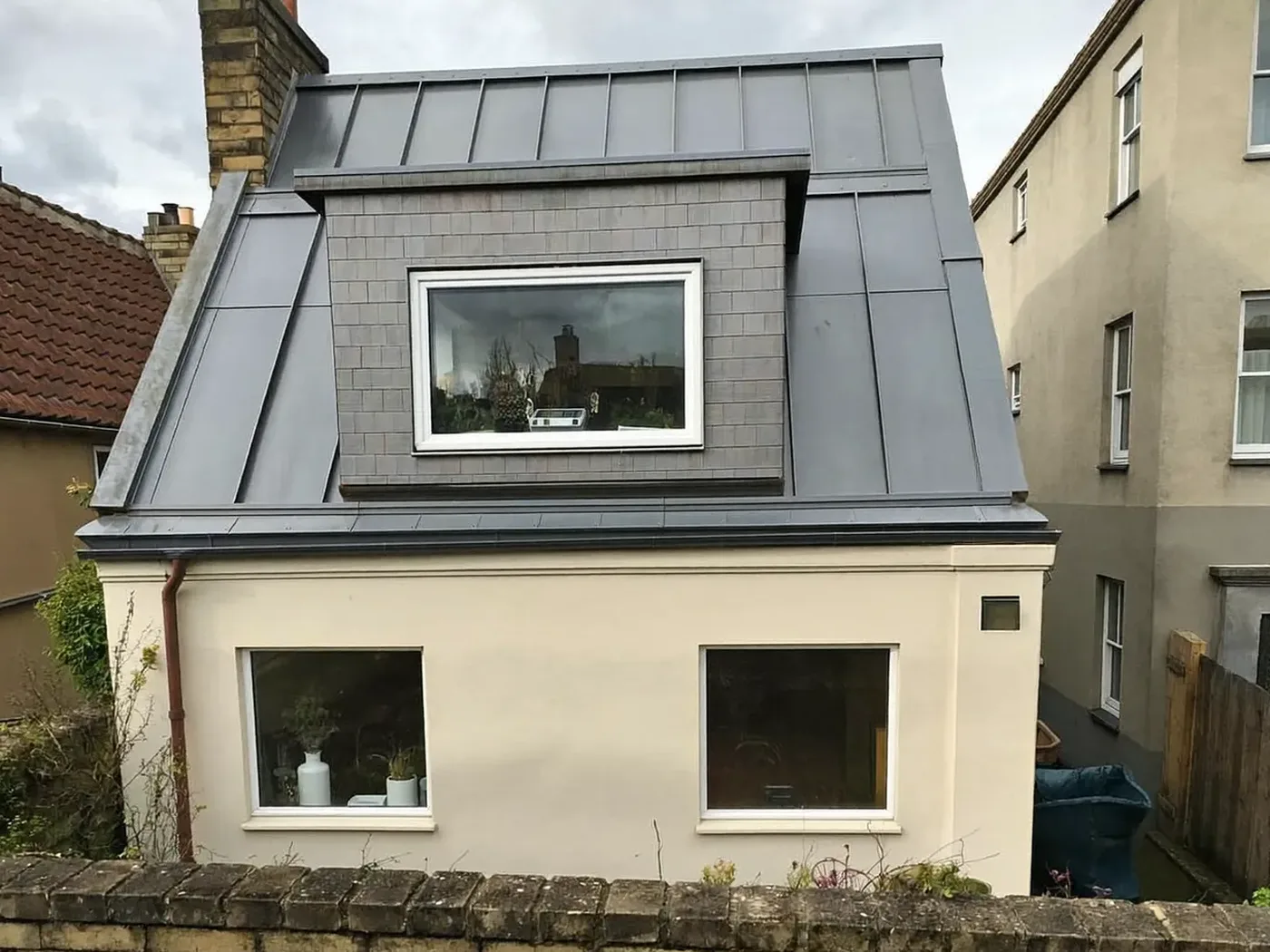 Newham: grey-clad box dormer loft conversion on the rear roof of a house with white windows