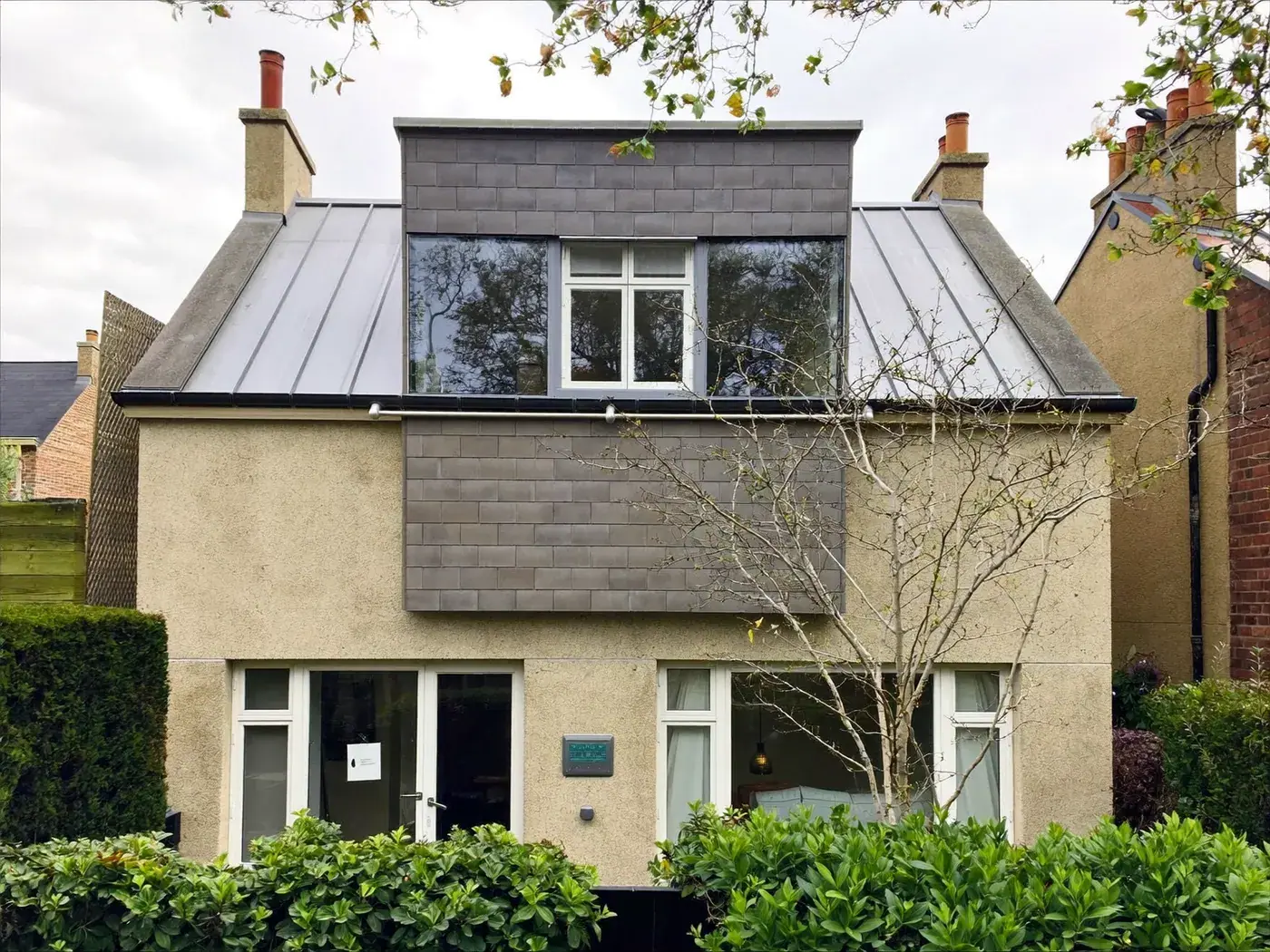Rickmansworth: grey-clad box dormer loft conversion on the rear roof of a house with white windows