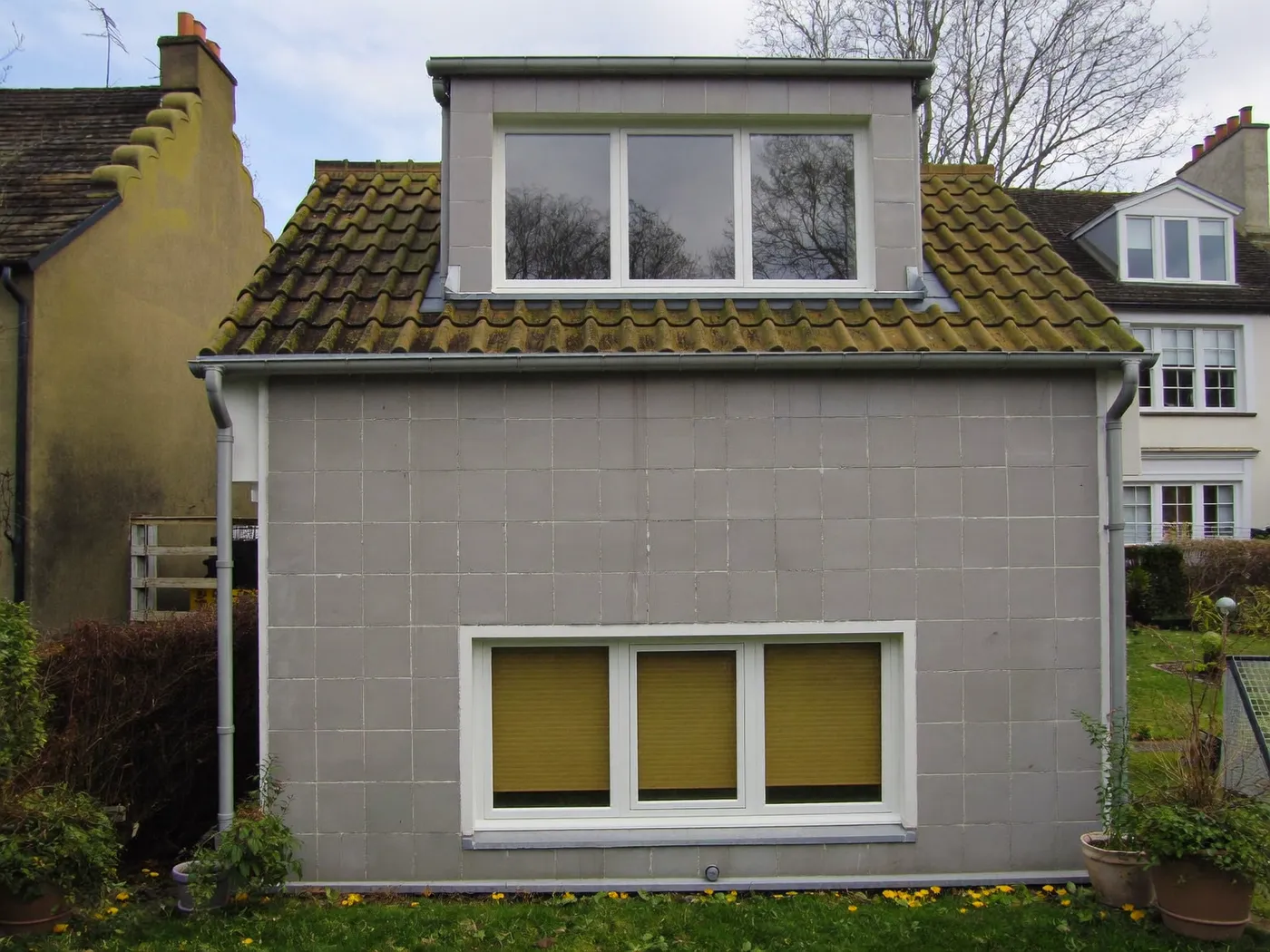 Southwark: grey-clad box dormer loft conversion on the rear roof of a house with white windows