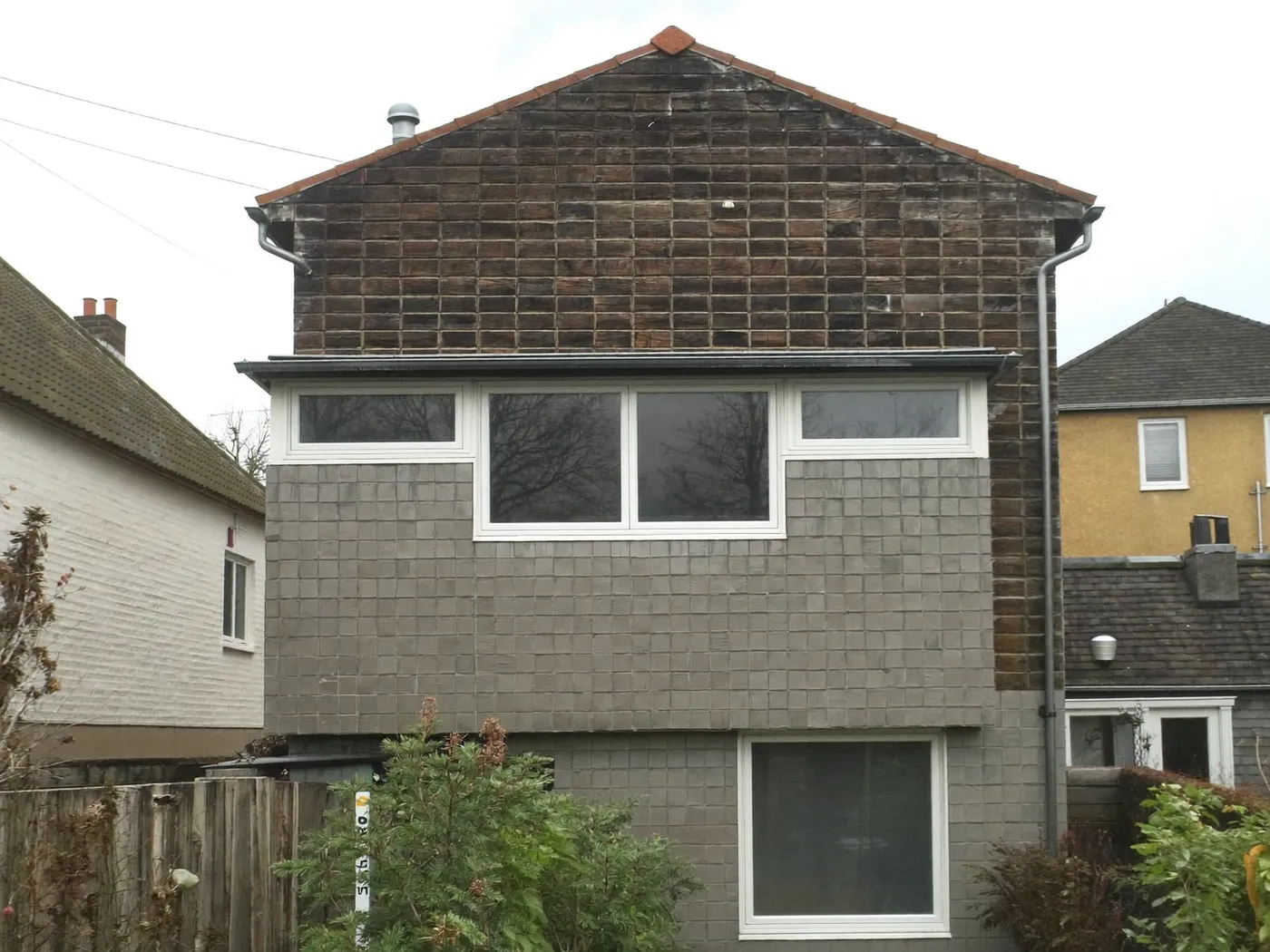 Sutton: grey-clad box dormer loft conversion on the rear roof of a house with white windows