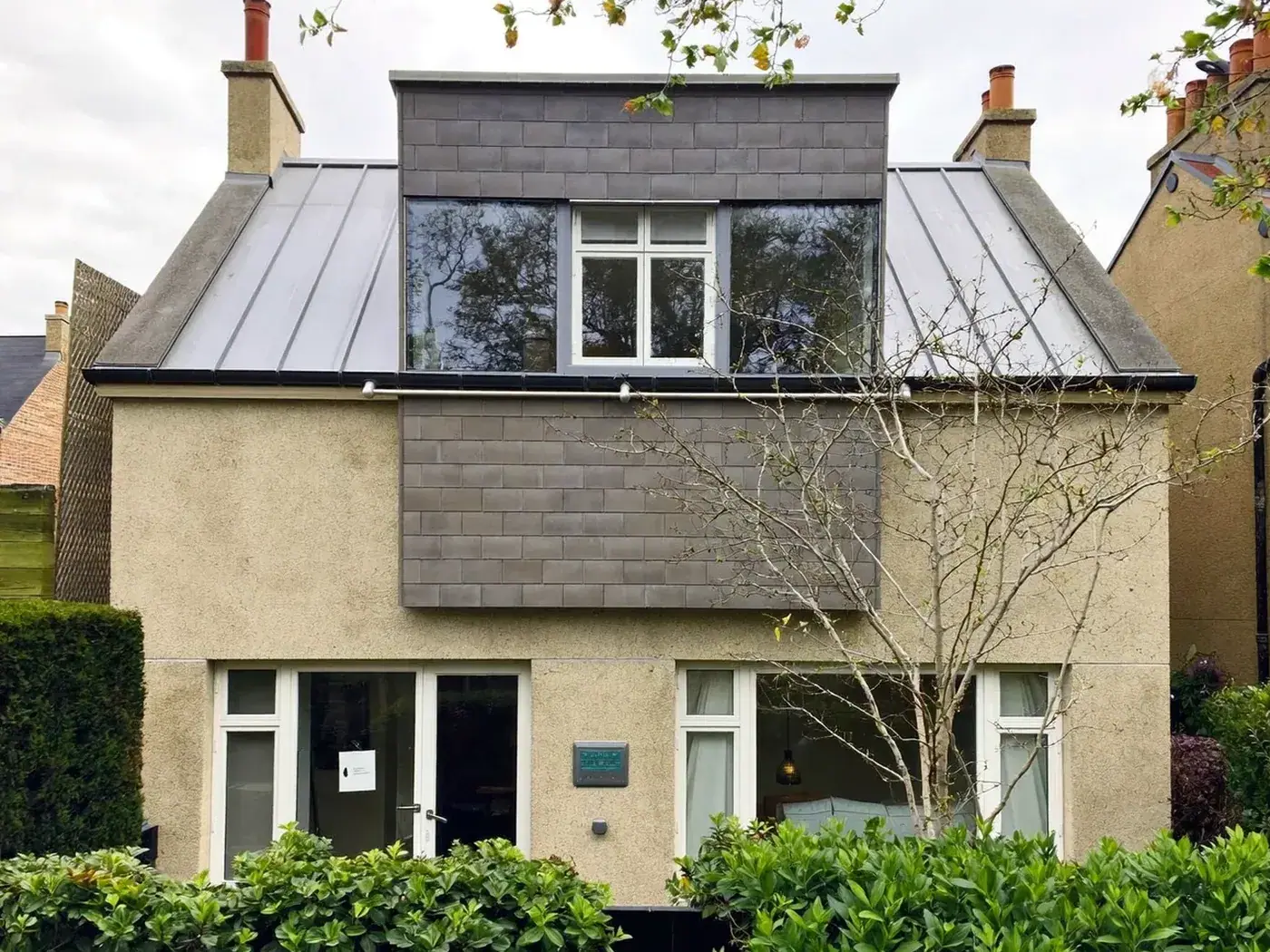 Tower Hamlets: grey-clad box dormer loft conversion on the rear roof of a house with white windows