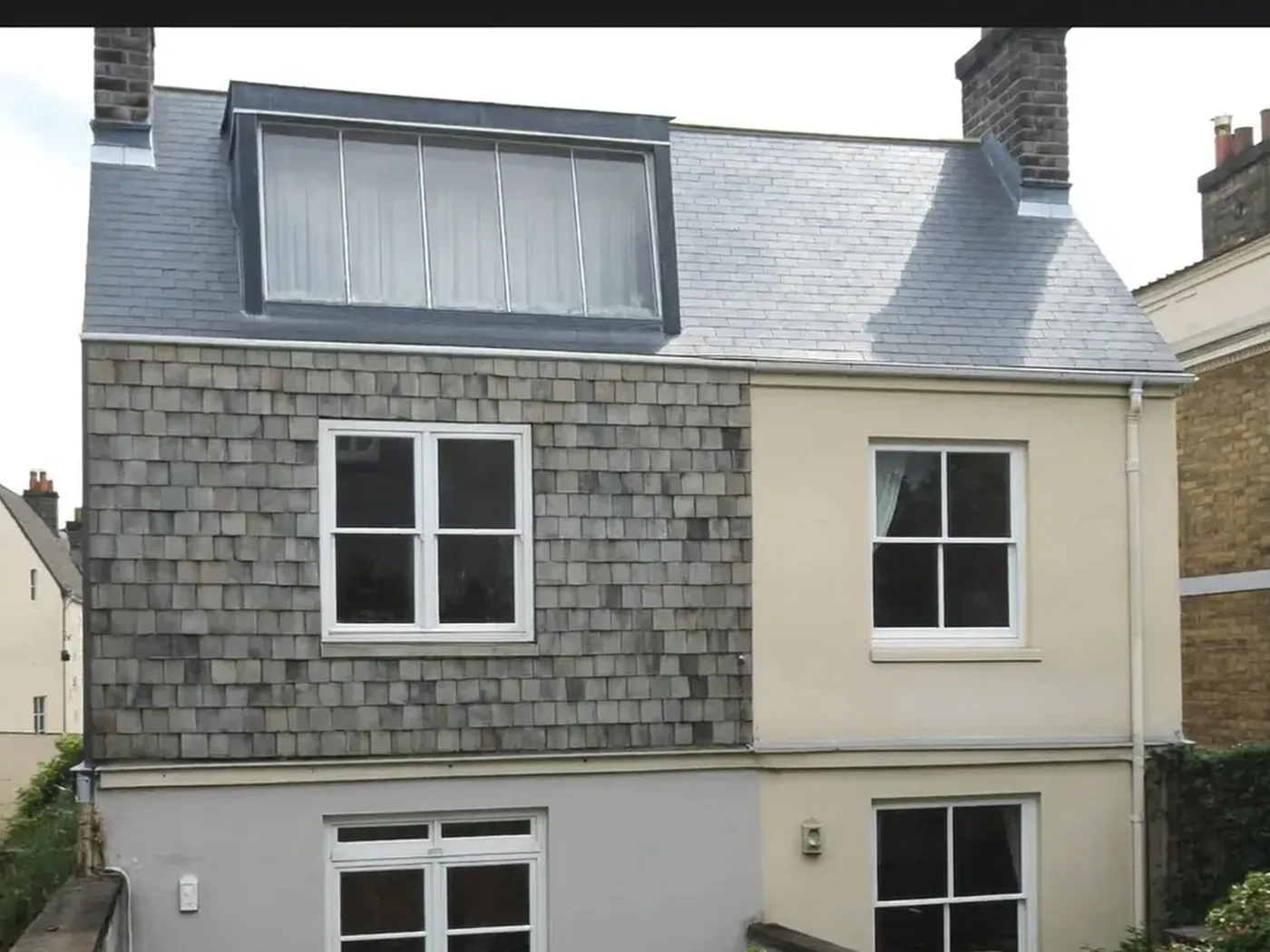 Waltham Forest: grey-clad box dormer loft conversion on the rear roof of a house with white windows
